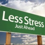 Green highway sign that says "Less Stress Just Ahead"