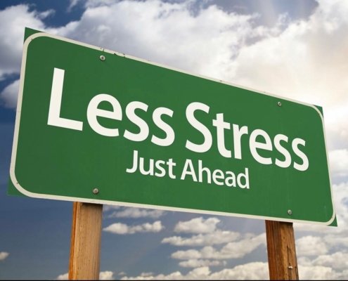 Green highway sign that says "Less Stress Just Ahead"